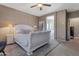 Serene main bedroom with white furniture, soft lighting, and an open doorway to the ensuite bathroom at 18023 W Statler St, Surprise, AZ 85388