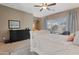 Bright main bedroom featuring neutral tones, a ceiling fan, and a picturesque window view at 18023 W Statler St, Surprise, AZ 85388