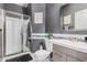 Modern bathroom featuring gray walls, a glass-enclosed shower, and stylish vanity with a decorative mirror at 45247 W Jack Rabbit Trl, Maricopa, AZ 85139