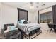 Comfortable bedroom featuring a stylish headboard, ceiling fan, and relaxing lounge chair at 45247 W Jack Rabbit Trl, Maricopa, AZ 85139
