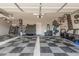 Large garage with checkered floors, ample storage, and a convenient workspace area at 45247 W Jack Rabbit Trl, Maricopa, AZ 85139