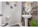 Elegant powder room featuring modern fixtures, wood accents, and decorative mirrors at 45247 W Jack Rabbit Trl, Maricopa, AZ 85139