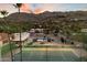 A beautiful backyard featuring a private pool and full-sized tennis court beneath the desert sunset at 4744 E Foothill Dr, Paradise Valley, AZ 85253