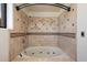 Bathroom featuring a deep soaking tub with tan tile surround, hand-held shower fixture, and inset lighting at 4744 E Foothill Dr, Paradise Valley, AZ 85253