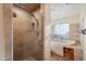 Bathroom with walk-in shower with glass door, soaking tub, tile surround, window, and open shelving at 4744 E Foothill Dr, Paradise Valley, AZ 85253