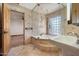 Bathroom featuring a walk-in shower, a step-up bathtub, and a pedestal sink with travertine flooring at 4744 E Foothill Dr, Paradise Valley, AZ 85253