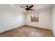 Simple bedroom features travertine floor, a ceiling fan with lights, and a window with outdoor view at 4744 E Foothill Dr, Paradise Valley, AZ 85253