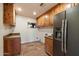 Laundry room boasts stone tile floors, wooden cabinets, and stainless steel refrigerator at 4744 E Foothill Dr, Paradise Valley, AZ 85253