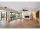 Living room with stone fireplace, tile floors, windows overlooking the yard, and a ceiling fan at 4744 E Foothill Dr, Paradise Valley, AZ 85253