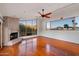Bright living room features a stone fireplace, wood floors, large windows with mountain views, and ceiling fan at 4744 E Foothill Dr, Paradise Valley, AZ 85253