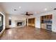 Living room with a stone fireplace, wood built-ins, wet bar, tile flooring, and a ceiling fan at 4744 E Foothill Dr, Paradise Valley, AZ 85253