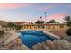 Backyard pool area with rock features, palm trees, and ample space for relaxation at 4744 E Foothill Dr, Paradise Valley, AZ 85253