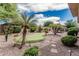 Lush backyard with putting green, desert landscaping, mature trees, and charming stone walkways at 5291 S Bradshaw Pl, Chandler, AZ 85249