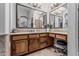 A bathroom vanity with warm wood cabinets, granite countertops, and a large framed mirror at 5291 S Bradshaw Pl, Chandler, AZ 85249