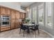 Cozy dining area with wood cabinetry, modern chandelier, and a view of the outdoor space through shuttered windows at 5291 S Bradshaw Pl, Chandler, AZ 85249