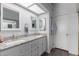 Bright bathroom with double sinks, granite countertops, white cabinets, and framed mirrors at 6320 W Mercer Ln, Glendale, AZ 85304