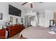 Comfortable bedroom with a large TV, ceiling fan, and a spacious closet for ample storage at 6320 W Mercer Ln, Glendale, AZ 85304
