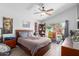 Comfortable bedroom with a large bed, ceiling fan, and plenty of natural light at 6320 W Mercer Ln, Glendale, AZ 85304