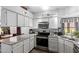 Modern kitchen with white cabinets, granite countertops, and stainless steel appliances at 6320 W Mercer Ln, Glendale, AZ 85304