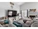 Bright and airy living room featuring a large TV, a cozy fireplace, and plenty of comfortable seating at 6320 W Mercer Ln, Glendale, AZ 85304