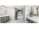 A modern bathroom with marble floors, grey cabinets, double sinks, soaking tub, and a walk-in shower at 7199 E Ridgeview Pl # 221, Carefree, AZ 85377