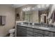 Bathroom featuring a grey vanity, dual sinks, and large mirror at 7199 E Ridgeview Pl # 221, Carefree, AZ 85377