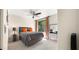 Modern bedroom with a grey bed, bright orange pillows, and windows overlooking a leafy green landscape at 7199 E Ridgeview Pl # 221, Carefree, AZ 85377