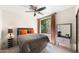 Modern bedroom with a grey bed, bright orange pillows, and windows overlooking a leafy green landscape at 7199 E Ridgeview Pl # 221, Carefree, AZ 85377