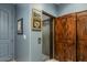 Private elevator with wood door in the hallway and artwork on the blue wall at 7199 E Ridgeview Pl # 221, Carefree, AZ 85377