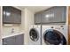 Bright laundry room with grey cabinets, a sink, and modern washer and dryer at 7199 E Ridgeview Pl # 221, Carefree, AZ 85377