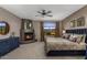 Cozy bedroom with fireplace, blue dresser, carpet, and large view window bringing in natural light at 7199 E Ridgeview Pl # 221, Carefree, AZ 85377