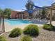 Community pool with sunshades, lounge chairs, and lush landscaping, perfect for summer days at 9137 W Coolbrook Ave, Peoria, AZ 85382