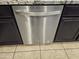 Stainless steel dishwasher with dark wood cabinetry and tile floors at 9137 W Coolbrook Ave, Peoria, AZ 85382