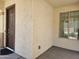 Inviting covered front porch showcases a solid front door and textured walls, offering a warm welcome and a view to outside at 9137 W Coolbrook Ave, Peoria, AZ 85382