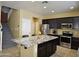 Well-equipped kitchen with dark cabinetry and spacious granite island at 9137 W Coolbrook Ave, Peoria, AZ 85382