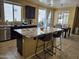 Spacious kitchen with granite island, bar seating, and modern lighting fixtures at 9137 W Coolbrook Ave, Peoria, AZ 85382