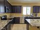 Modern kitchen with granite countertops, stainless steel appliances, and dark wood cabinetry at 9137 W Coolbrook Ave, Peoria, AZ 85382