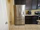 Modern kitchen featuring stainless steel refrigerator, dark wood cabinets, and granite countertops at 9137 W Coolbrook Ave, Peoria, AZ 85382