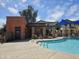 A community pool is surrounded by lounge chairs, with the pool house in the background and a bright blue sky at 9137 W Coolbrook Ave, Peoria, AZ 85382