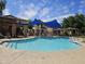 Community pool with clear water, lounge chairs and a shaded seating area at 9137 W Coolbrook Ave, Peoria, AZ 85382