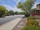 A serene community street showcasing lush landscaping, sidewalks, and inviting townhomes at 9137 W Coolbrook Ave, Peoria, AZ 85382