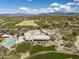 Stunning aerial view of clubhouse, pool, and golf course surrounded by lush greenery and mountain views at 9154 E Sunflower Ct, Scottsdale, AZ 85266