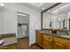 Bathroom featuring granite counters, wood cabinets, skylight, and closet with hanging robe at 9154 E Sunflower Ct, Scottsdale, AZ 85266