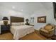Bright bedroom featuring a queen bed, side tables with lamps, a chair, and artwork at 9154 E Sunflower Ct, Scottsdale, AZ 85266