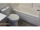 Bathroom featuring toilet, tub, modern faucet, and quartz countertop at 11827 W Roanoke Ave, Avondale, AZ 85392