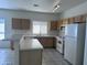 Bright kitchen featuring wooden cabinets, white appliances, and a spacious quartz countertop at 11827 W Roanoke Ave, Avondale, AZ 85392