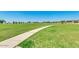 Expansive green space in community park, featuring a concrete walking path at 1320 W Kennedy Ave, Coolidge, AZ 85128
