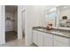Bathroom features a dual sink vanity with granite countertop, white cabinetry and a walk-in closet at 1360 W Hess Ave, Coolidge, AZ 85128