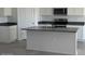 Modern kitchen featuring an island with a sink and dark countertop paired with white cabinets at 1360 W Hess Ave, Coolidge, AZ 85128