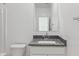 Well-lit bathroom with a single sink vanity, granite countertop, toilet, and a clean, minimalist aesthetic at 1408 W Hess Ave, Coolidge, AZ 85128